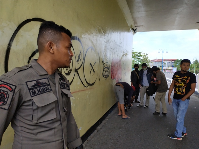 Anggota Pol PP Kota Pariaman berikan sanksi kepada pelaku vandalisme dengan cara disuruh membersihkan fasilitas yang telah dicoret Kamis (6/8/2020). YUHENDRA