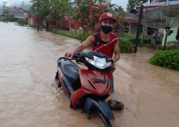 Seorang warga Pessel mendorong sepeda motor di tengah bencana banjir di Painan, Rabu (23/09/2020). Hingga berita ini ditulis, intensitas hujan masih tinggi di Kota Padang dan Kabupaten Pesisir Selatan. OKIS