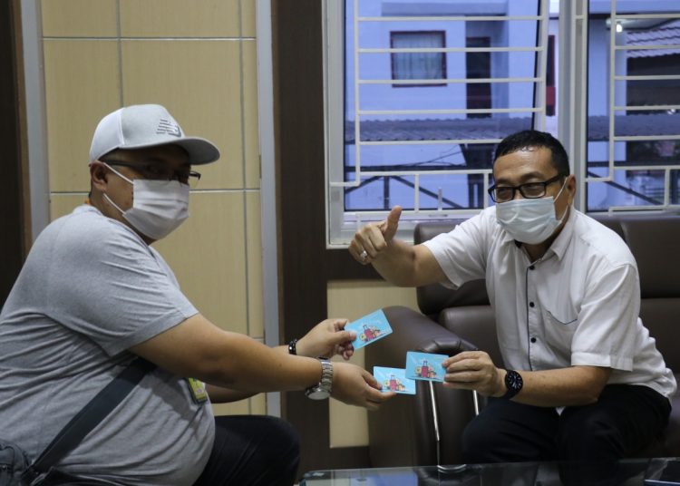 Perwakilan BRI Cabang Padang Rezki Rifai menyerahkan tiga buah uang elektronok BRI (BRIZZI) kepada Jubir Covid-19 Sumbar, Jasman Rizal, di ruang kerjanya Rabu (16/9/2020). IST