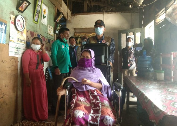Bupati Hendrajoni didampingi istri saat menyerahkan bantuan kursi roda kepada salah satu warga berkebutuhan khusus di Kampung Koto Panjang, Nagari Taluak Tigo Sakato, Kecamatan Batangkapas.OKIS