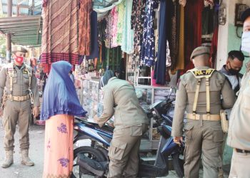 Anggota Satpol PP Padang melakukan pendataan kepada warga yang tidak menggunakan masker saat sosialisasi yang dilakukan di Pasar Alai, Senin (28/9/2020). IST