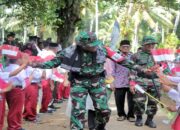 Sambut Kedatangan Komandan Satgas TMMD di Pesisir Selatan, Seratusan Siswa SD Kibarkan Bendera Merah Putih